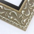 A large, reverse curve profile frame with an intricate leaf design bordered by a geometric outer edge and beaded inner lip. A dark Silver base with foil patina for added depth on the topmost points of the design. Strong, solid wood construction.
3.25 " witdth: ideal for large and oversize (extra large) images.